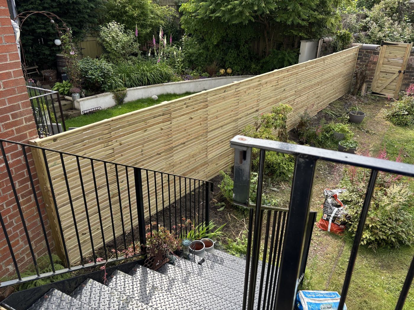Slatted fence stepped down the sloped garden
